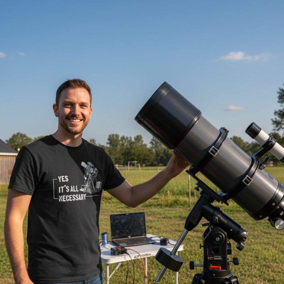 Man holding a large telescope outdoors with a laptop on a table in the background.